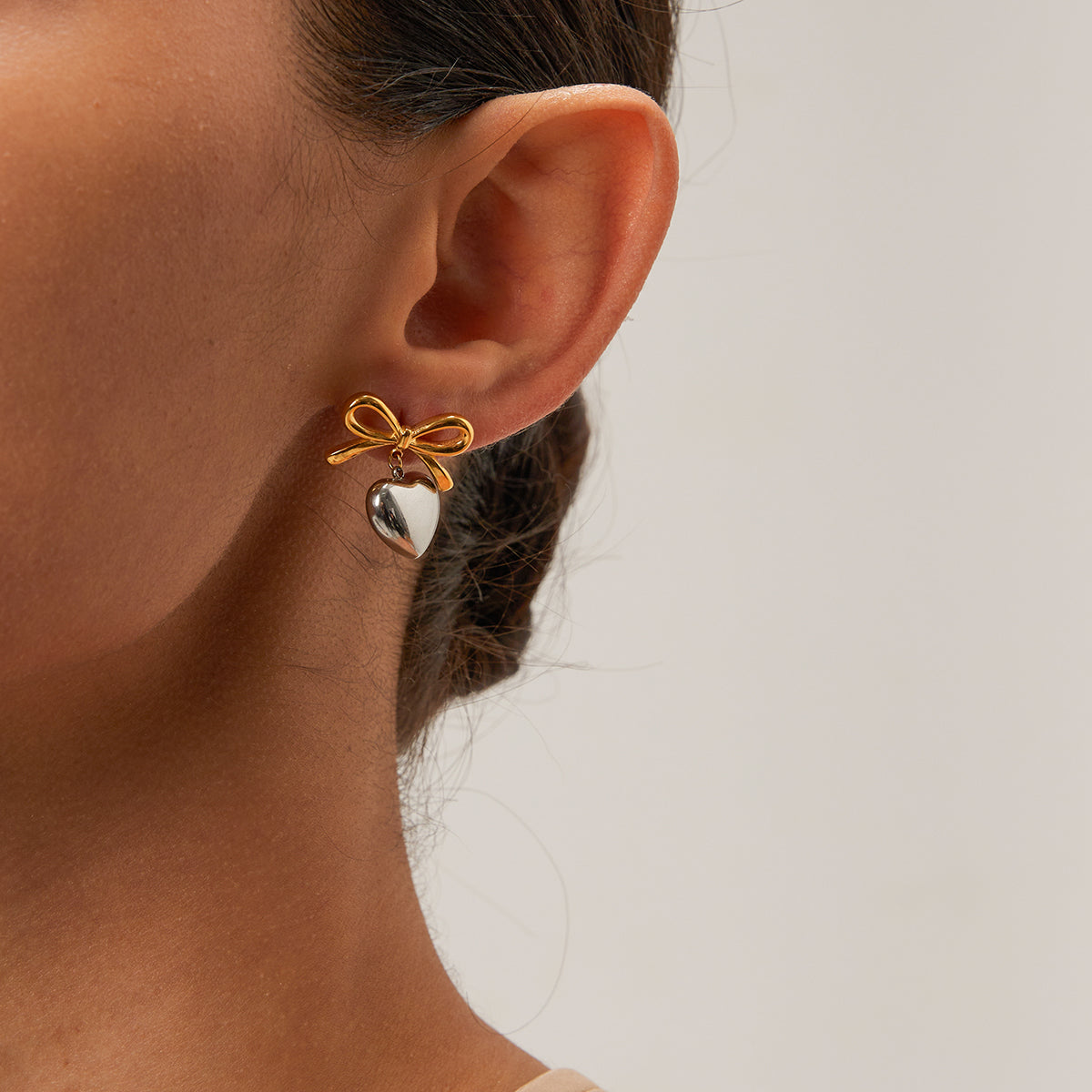 Sweet Bow Heart – Golden bow earrings with a silver heart